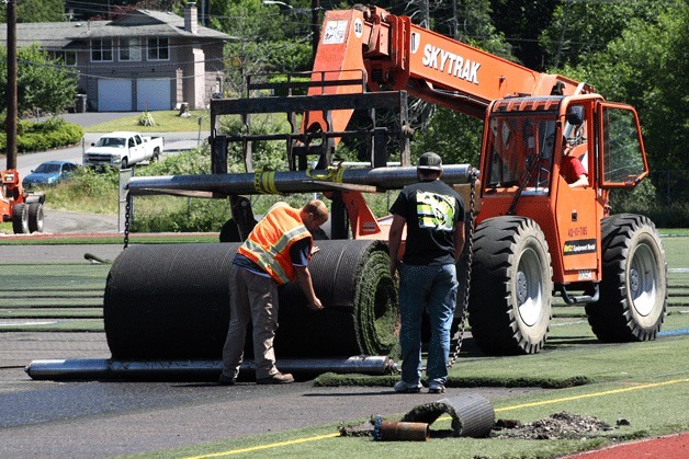 Construction workers remove turf from the football field at Juanita High School on Friday. The Lake Washington School District had the field removed and replaced at an estimated cost of $910