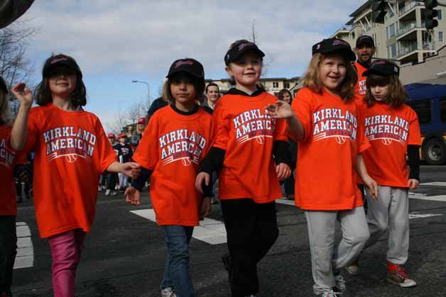 Youngsters wave to spectators during last year's Kirkland American Little League parade in downtown Kirkland. This year's parade