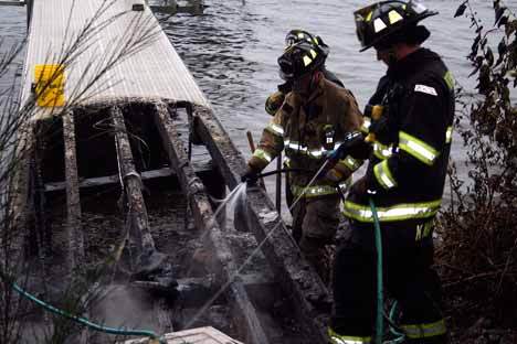 Kirkland firefighters work to put out a dock fire down the hill from N.E. Juanita Drive.