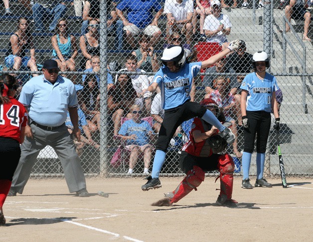 Brynn Radke of Kirkland attempts to leap over the tag of the catcher from Canada during the opening game of the Junior Softball World Series. Kirkland won the game 5-3.
