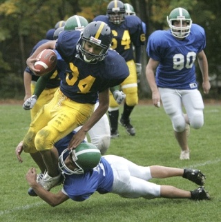 Finn Hill running back Travis Marshall (No. 34) tries to break free from a tackle by the Evergreen defense during a game at Finn Hill Junior High School on Friday