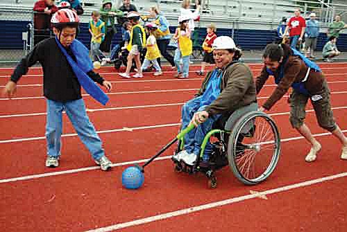 Tom Carnaham races down the track with the help of other blue team members during the 2010 Wacky Wheelays.