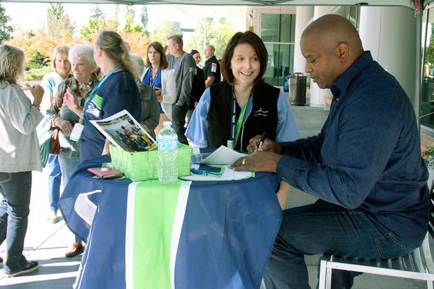 EvergreenHealth X-ray technician Erin Pool meets with former Seattle Seahawk and current broadcaster Mack Strong in front of the hospital during a prostate awareness event in Kirkland. This was the sixth year Strong has volunteered for the event.
