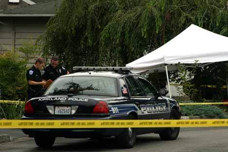 Kirkland Police officers wait for warrants to search the house where a man was shot in the face late Tuesday night.