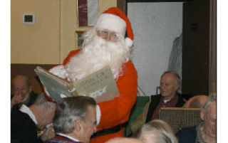 Some Old Timers chuckle as Santa Claus reads them a story during a meeting last Thursday