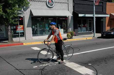 A city employee shows where bicyclists are to stop to trigger stop lights.