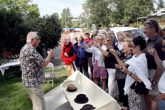 Former Kirkland Mayor Bill Woods raises a toast to long-time friend Charles 'Chuck' Morgan during a bench dedication in Morgan's honor at Marsh Park on Saturday.