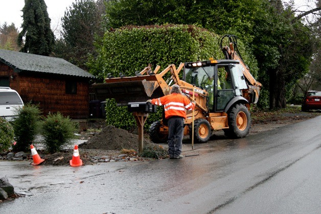 City of Kirkland Public Works crew repair the road that was dug up to fix a water main break that occurred Thursday night. Sixteen homes went without running water and two were flooded.