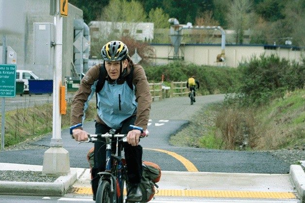 Local cyclists risk impending rain clouds as they ride on the Cross Kirkland Corridor through the Totem Lake neighborhood of Kirkland on Monday afternoon.