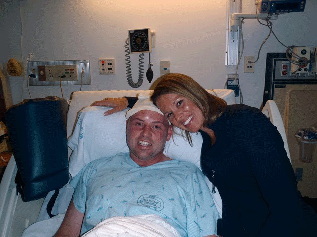 David Heyting with his wife after surgery. Doctors removed a golf-ball-size tumor from his brain they discovered after he had a seizure while at a Starbucks in Seattle in 2011. Heyting couldn’t control his left hand after surgery but worked to overcome it. Below: Supporters of David Heyting hold up “Defeat Goliath” signs. Goliath is the name that his family gave his brain tumor that he is currently battling. The Rotary Club of Kirkland Downtown