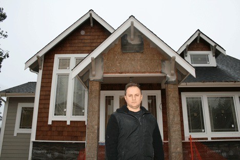 Leonid Milkin stands in front of his partially rebuilt Kirkland home on Slater Avenue. The house was burned down three years ago by Conner Schierman