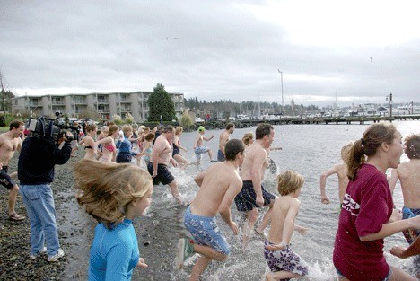 Nearly 50 people plunge into the 45 degree water of Lake Washington at Marina Park New Year's Day.