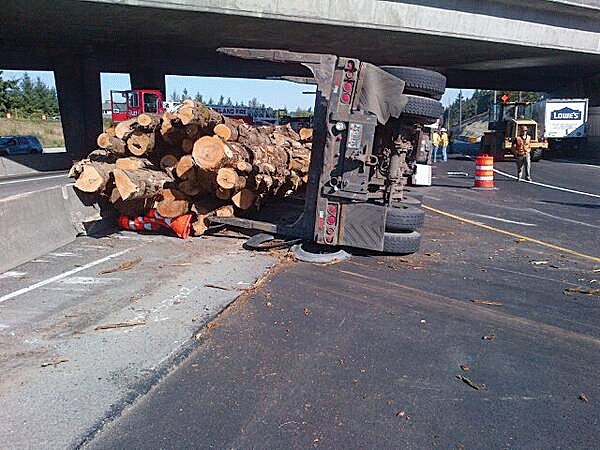 A fully loaded logging truck tipped over on an Interstate 405 ramp in Kirkland Wednesday morning. Below
