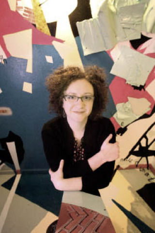 Artist Julie Alpert stands among her artwork in a staircase at the Kirkland Arts Center on Fri.
