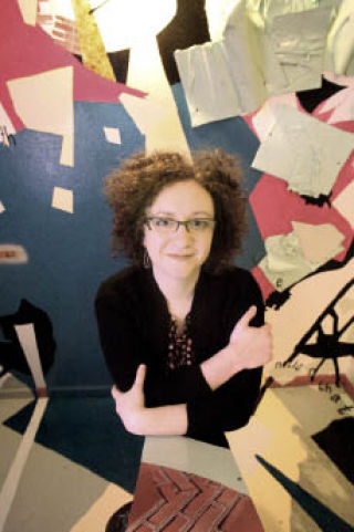 Artist Julie Alpert stands among her artwork in a staircase at the Kirkland Arts Center on Fri.
