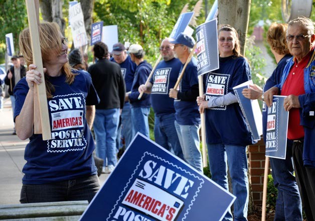 Dozens of Postal Service workers rallied at Congressman Dave Reichert's office on Mercer Island Tuesday to urge him to support legislation resolving post office financial problems.