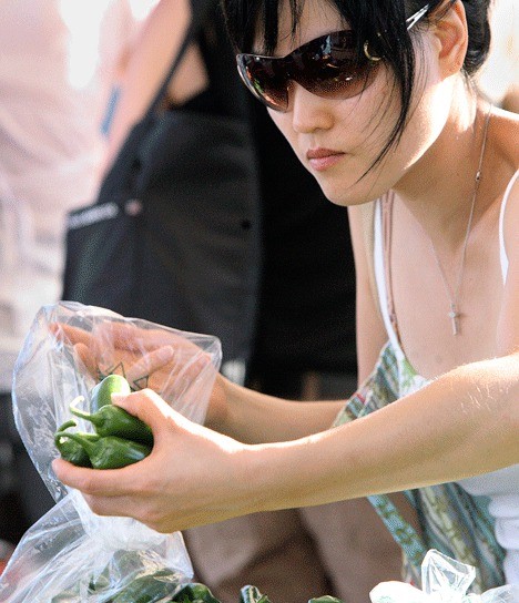Jin Kang selects peppers from the Magana Farms booth during a visit to the Kirkland Wednesday Market.