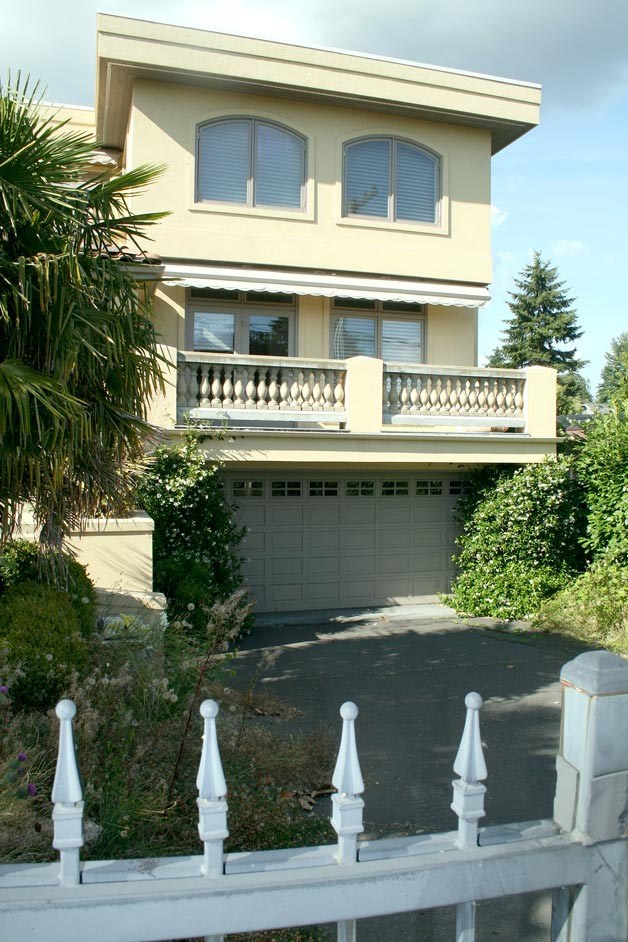 A jammed-open security gate crosses a driveway at a vacant house on Seventh Avenue that's part of a legal fighting involving hundreds of millions of dollars.