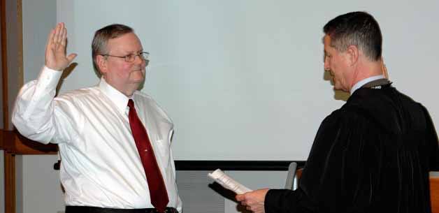 Kingsgate neighborhood resident Toby Nixon takes the oath of office for his new position on the Kirkland City Council on Tuesday night.