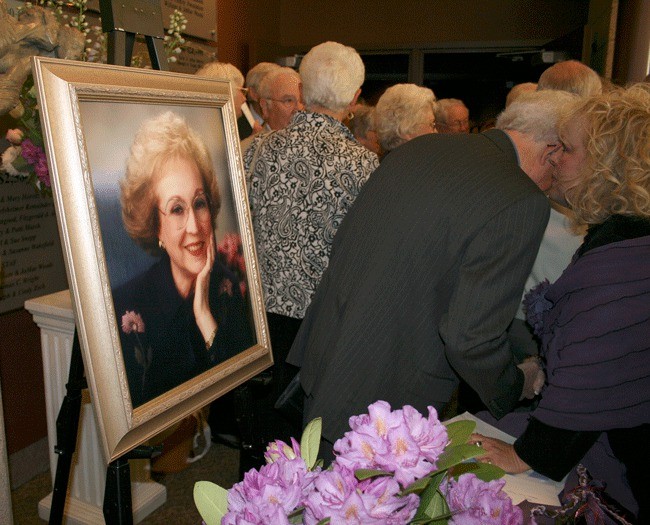 G.G. Getz (far right) speaks with John Woodbery following the memorial service for long-time Kirkland resident JoMae Woods at the Kirkland Performance Center Thursday.