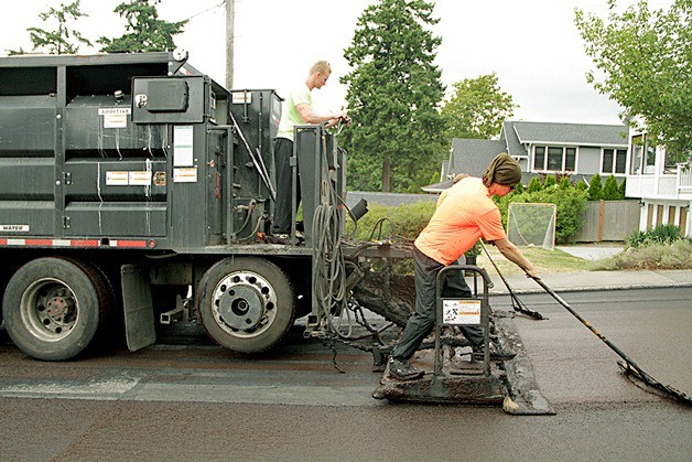 The summer crews of Kirkland’s 2014 slurry seal contractor smooth out the slurry seal in August 2014 on Market neighborhood’s Sixth Street West.