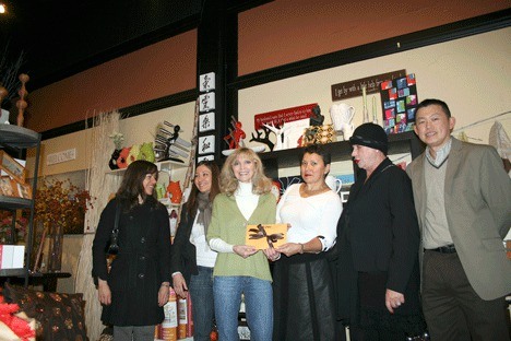 A group of downtown Kirkland merchants present a check to Bonne VeVea (center) of Meow Cat Rescue Tuesday. From right: 'A' Liengboonlertchai