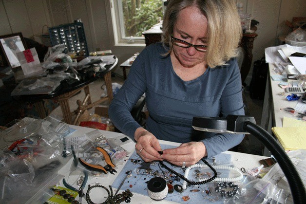 Jewelry designer Coralyn Whitney works on a beaded necklace in her studio at her Kirkland home. Whitney will be one of more than 55 artists featured in the Kirkland Artist Studio Tour on Mother's Day weekend