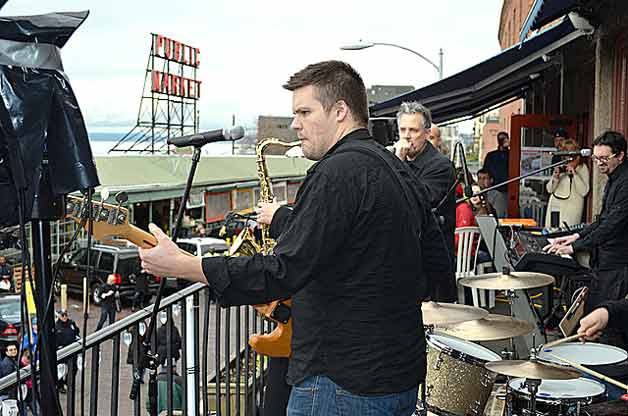 Beatles tribute band Creme Tangerine performs on a rooftop at the Pike Place Market on Friday.