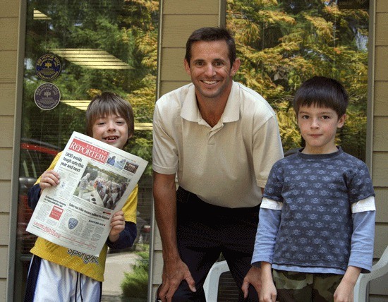 Reporter Publisher Mike Walter stands in front of the Kirkland Reporter Newspaper’s office with Cub Scout Anthony Harden (left)