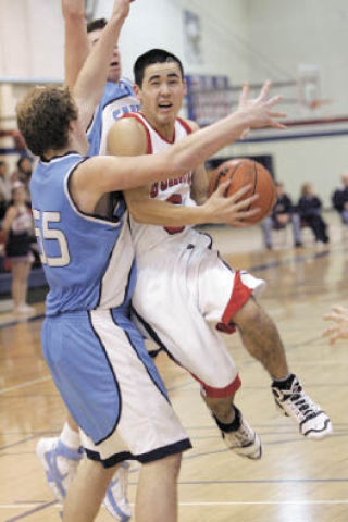 Juanita’s Jake Ichikawa (No. 5) pushes his way through the Interlake defense on his way to the basket during a game at Juanita High School Feb. 10. Juanita built a big lead early