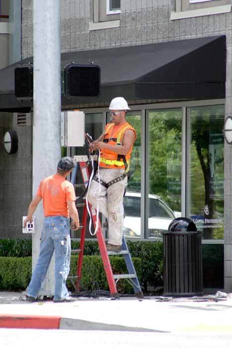 Utility workers connect the new traffic lights at the corner of State Street and Kirkland Avenue