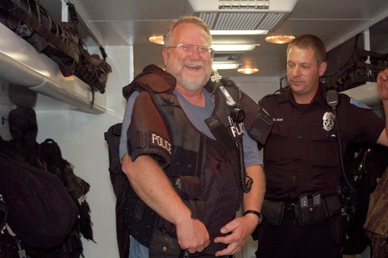 Highlands resident Jim Szabo tries on police gear at the National Night Out Against Crime event he organized on Aug. 3 in his neighborhood. In addition to ice cream sundaes; 50 neighbors were treated to a visit by a fire truck