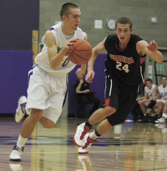 Lake Washington's Drew Heimdahl runs down court with the ball as Juanita's Brett Hamre closes in. The Kangs won the game.