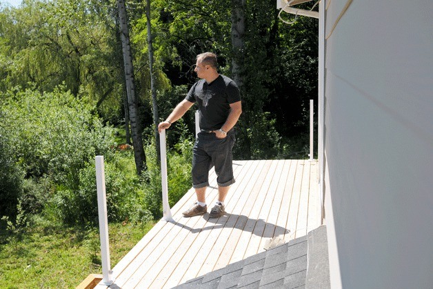 Leonid Milkin stands on his unfinished porch off the master bedroom during the rebuild of his Kirkland home on July 14.