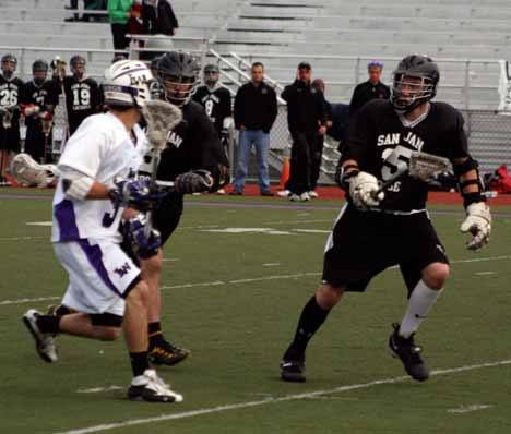 Lake Washington's Jake Bernstein takes on two Dragon defenders during the state semifinal game at Mac Field on Wednesday. The Kangs were illuminated from the state playoffs with the 9-8 loss to San Juan.