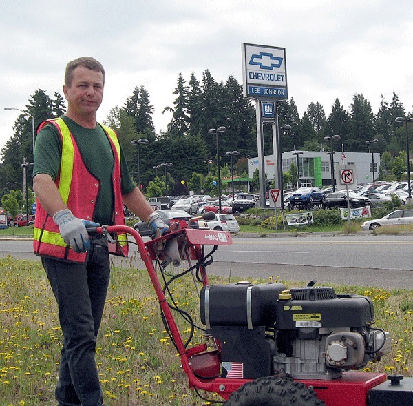 Adrian Ionescu mows the triangle by the 85th Street on ramp in Kirkland.
