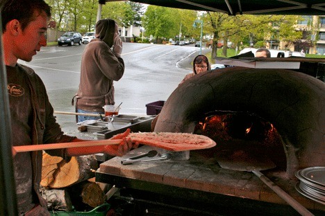 Dale Berg prepares a pizza as co-worker Bryan Ohman looks on. Both work for Veraci Pizza.