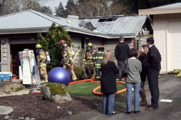 Firefighters exit a house in the Norkirk neighborhood of Kirkland after extinguishing a single-structure fire two blocks from Peter Kirk Elementary School.