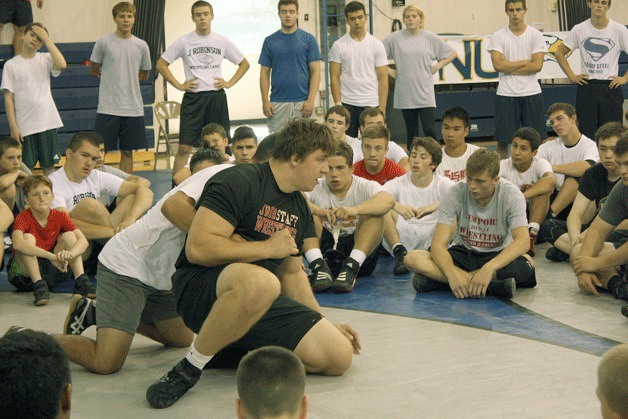 Tony Nelson shows youngsters at a wrestling camp a technique.