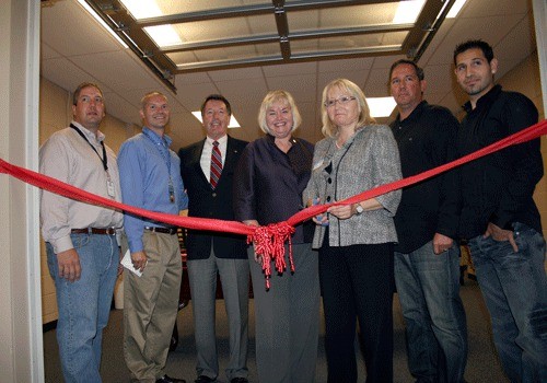 Dignitaries stand behind Kirkland Mayor Joan McBride (third from right) as she prepares to cut the ribbon for the new 1