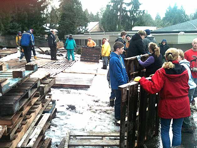 Volunteers unload and place palettes on the ground that will go under tents for Tent City 4 residents at Holy Spirit Lutheran Church on Saturday.