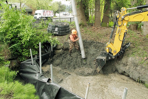 A city of Kirkland maintenance worker pumps sediment out of Cochran Springs. Cochran Springs deposits more than 30 tons of sediment each year downstream of Lake Washington Boulevard. That sediment chokes the culverts and the creek