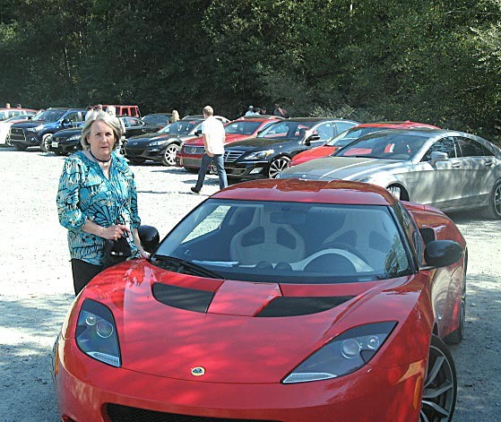 Sally Hanson alongside the Lotus Evora S with the rest of the Run to the Sun fleet in the background.