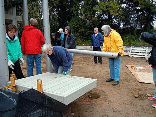 Rotary Club of Kirkland volunteers help to construct a playground at Rose Hill Meadows Park.