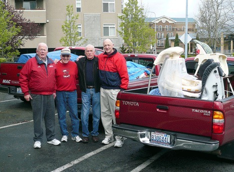 Kirkland Kiwanis members unload three truck loads of donations for Eastside Baby Corner at Fox Cleaners recently. From left
