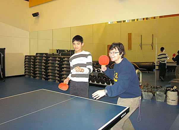 Finn Hill Junior High teacher Kerri McGibbon plays a game of ping pong with student Vincent Chan. Below