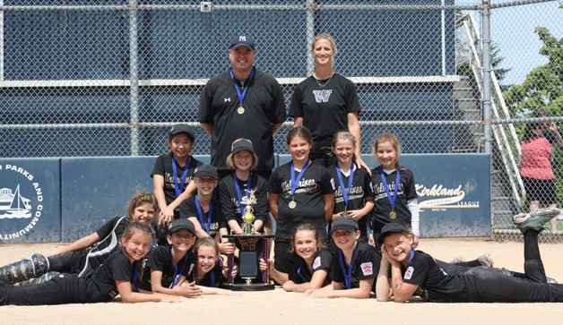 The Wolverines won the city championship on June 15. Pictured here at Everest field with the championship trophy are: (Bottom