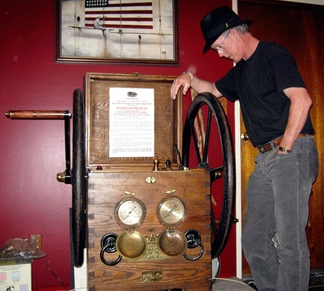 Kirkland resident Bradley 'Mitch' Mitchell poses with his 'pride and joy' - an 1893 Navy diving pump he purchased from a Bellevue resident. Mitchell will show off his old Navy diving gear collection this weekend at the Seattle Aquarium.