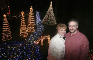 Barbara and Bob McConnell stand in front of a portion of a light display at their home. The 40