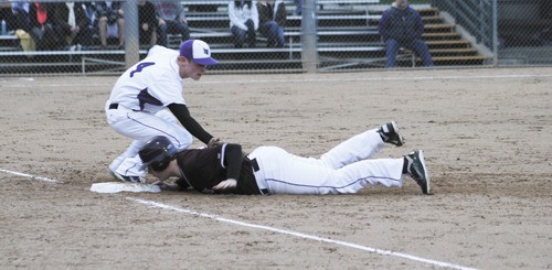 Lake Washington's Zach Johnson tries to tag out Mercer Island's Max Dammeier at first base during the Kangs 12-11 extra inning win over the Islanders on April 8.
